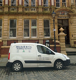 Mitchell & Co Van in front of a building